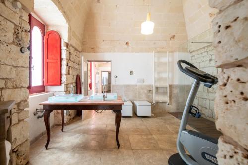 La salle de bains est pourvue d'une table avec deux lavabos et d'un tapis de course. dans l'établissement Relais Porta del Sud, à Ostuni