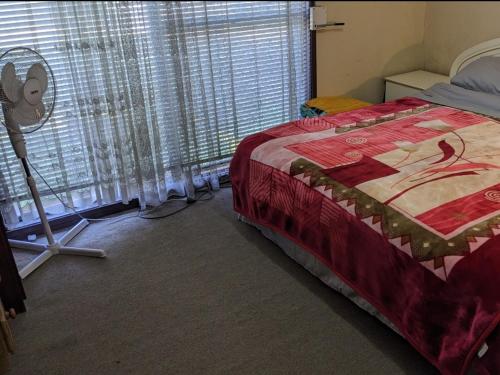 a bedroom with a bed and a large window at BIDWILL GARDENS - 2 Rooms A Private Room with a King-Size Bed or Open Lounge Room Floor Mattress SHARED Bathroom FREE Kitchen Essentials FREE Laundry Facilities Fast NBN WIFI HDTV NETFLIX, YOUTUBE, KAYO Meal and Transport Service Available in Sydney