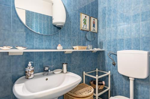 Baño de azulejos azules con lavabo y espejo en Perugia Studio - Historic Center Stunning View, en Perugia
