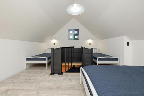 a room with two beds in a attic at Domek OŚĆ - przy samej plaży in Dziwnówek