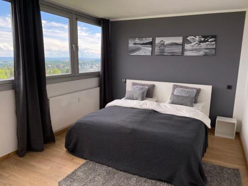 a bedroom with a bed and a large window at Skyline Appartement mit Pool and Netflix in Kronberg im Taunus