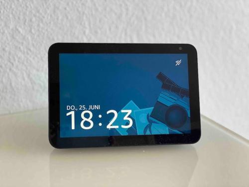 a tablet computer sitting on a table with a clock at Skyline Appartement mit Pool and Netflix in Kronberg im Taunus