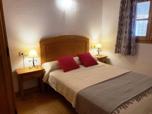 1 dormitorio con 1 cama grande y 2 almohadas rojas en Casa 3-h, en Sant Francesc Xavier