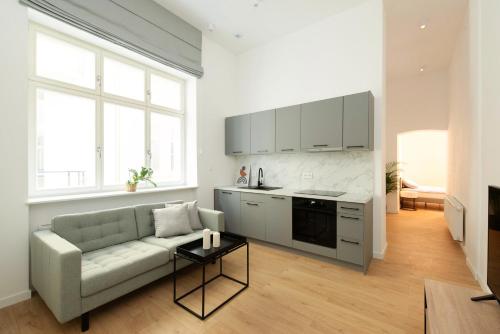 a living room with a couch and a kitchen at The Bank Poznan Apartments in Poznań