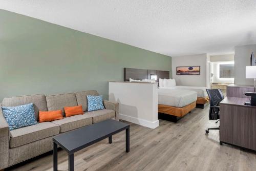 a hotel room with a couch and a bed at Quality Inn & Suites Orlando East - UCF Area in Orlando