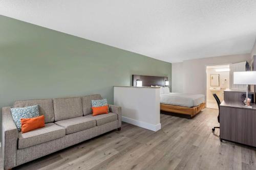 a living room with a couch and a bed at Quality Inn & Suites Orlando East - UCF Area in Orlando