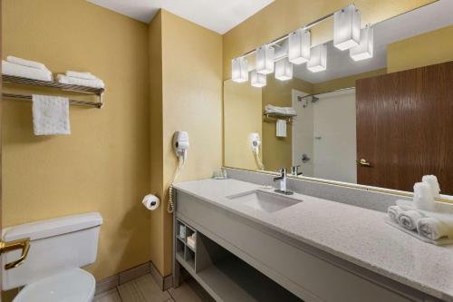 ein Bad mit einem Waschbecken und einem Spiegel in der Unterkunft Quality Inn in Warrensburg