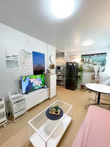 a living room with a tv and a table at Tower Resident in the Heart of Bangkok Shopping Center in Makkasan