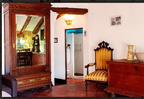 um quarto com um espelho, uma cadeira e uma cómoda em Casa Valor em Penáguila