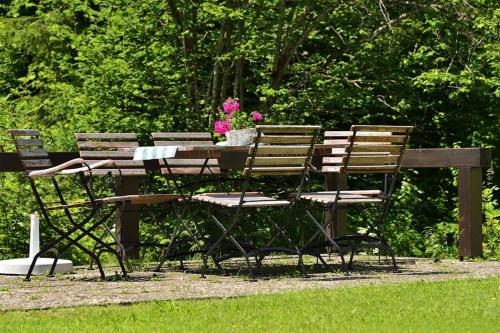a wooden table and chairs with flowers on it at Landhaus Bachtelmühle in Bolsterlang