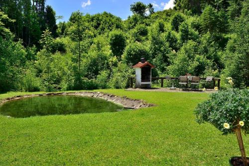 a garden with a small pond and a gazebo at Landhaus Bachtelmühle in Bolsterlang