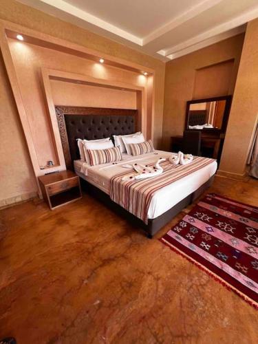 a bedroom with a large bed and a rug at Les jardins d’ailleurs in Marrakech