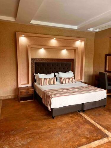 a bedroom with a large bed in a room at Les jardins d’ailleurs in Marrakech