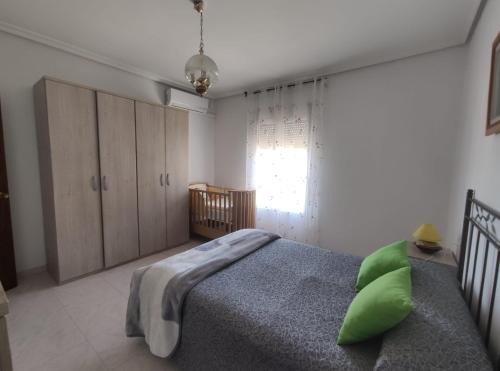 a bedroom with a bed with a green pillow on it at Casa Quico in Higuera de Arjona