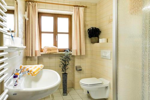 a bathroom with a sink and a toilet and a tub at Landhaus Bachtelmühle in Bolsterlang