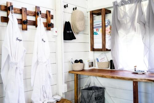 a bathroom with white walls and a wooden shelf at Silk Cotton Cottages in Parrot Hall