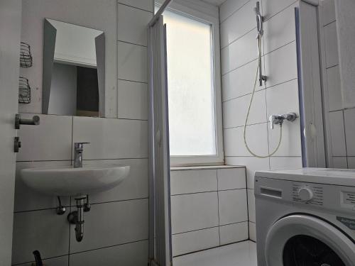 a bathroom with a washing machine and a sink at Betty Zimmer in Heilbronn Zentrum in Heilbronn