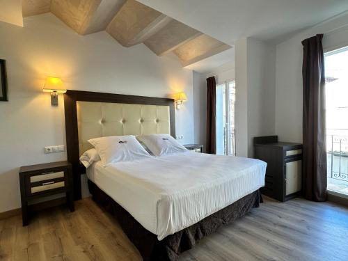 トレドにあるAntídoto Rooms Zocodoverのベッドルーム(白いシーツを使用した大型ベッド1台付)
