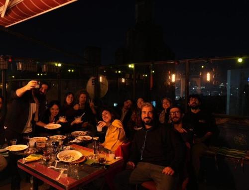 a group of people sitting at a table at night at galata west hostel in Istanbul