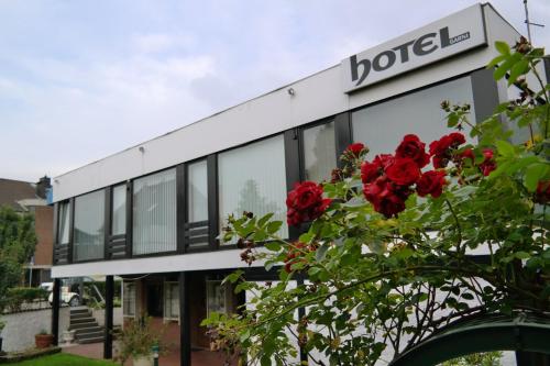 a building with red roses in front of it at Am Hallenbad Hotel garni in Ratingen