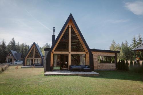 a large wooden house with a large window at Popovic SPA house Tara in Ljuboš