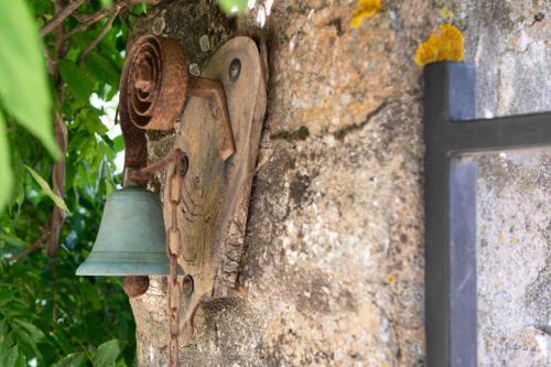 a bell on the side of a stone wall at La Terrade 