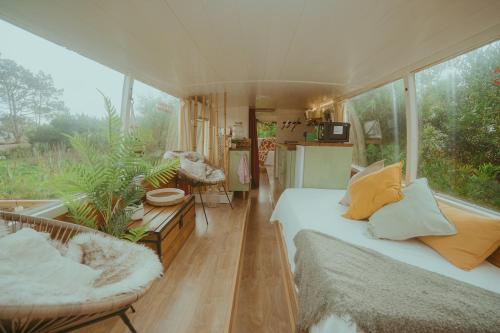 een kamer met een bed en een bank in een kamer met ramen bij The Amazing Inácio Bus converted home in Sintra