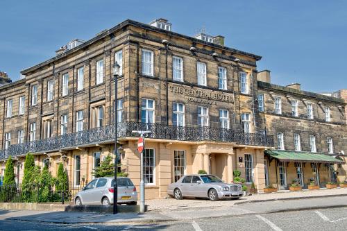 a building with two cars parked in front of it at The Central Hotel in Scarborough