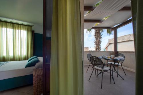 a bedroom with a bed and a table and chairs at Insula Hotel in Favignana