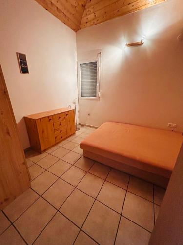 a small bedroom with a bed and a wooden cabinet at Balaton lake view 30 m from Beach in Fonyód