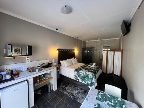 a hotel room with a bed and a sink at Midway En Route in Harrismith