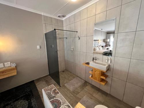 a bathroom with a shower and a sink and a tub at Midway En Route in Harrismith