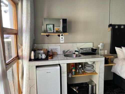 a small kitchen with a sink and a microwave at Midway En Route in Harrismith