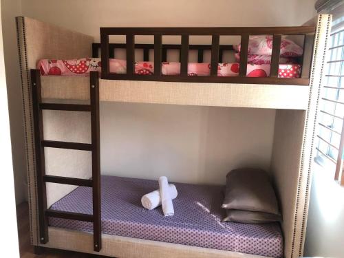 a bunk bed with a teddy bear sitting on the bottom shelf at Jaleen Transient in Batangas City