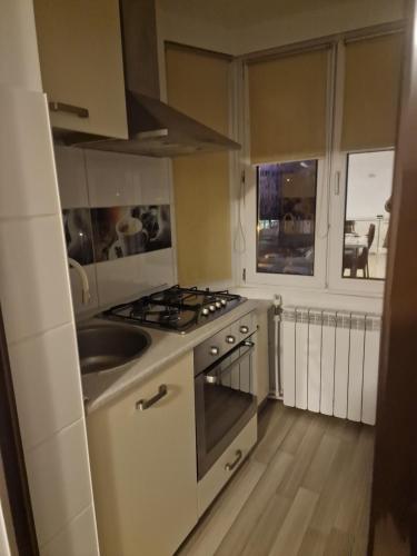 a kitchen with a stove top oven next to a sink at 2 bedrooms Apartment. in Galaţi