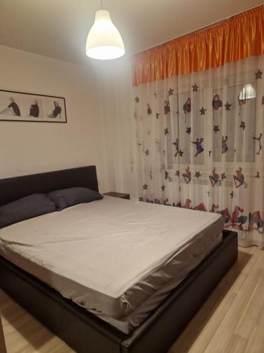 a bedroom with a bed in a room with a curtain at 2 bedrooms Apartment. in Galaţi