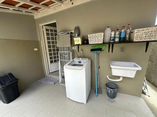y baño con lavadora y lavamanos. en Villa do Aconchego · Próxima ao centro São João da Boa Vista · Casa inteira, en São João da Boa Vista