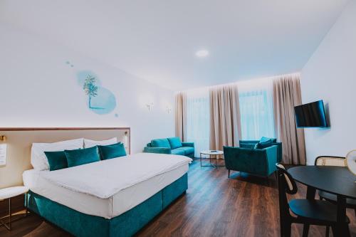 a hotel room with a bed and a table and chairs at Resort Český les in Bělá nad Radbuzou