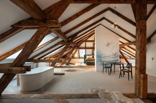 an attic room with a tub and a table at Resort Český les in Bělá nad Radbuzou