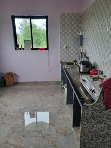 a kitchen with a counter and a window in it at Raje Bhosale Farm in Ghātgarh