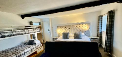 a bedroom with two bunk beds and a couch at Saughy rigg farm in Haltwhistle