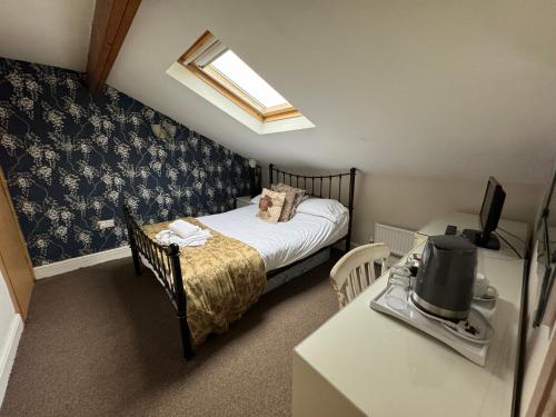 a bedroom with a bed and a desk with a television at Saughy rigg farm in Haltwhistle