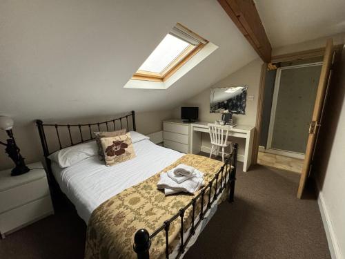 a bedroom with a bed and a desk and a window at Saughy rigg farm in Haltwhistle