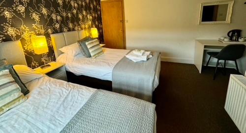 a hotel room with two beds and a desk at Saughy rigg farm in Haltwhistle