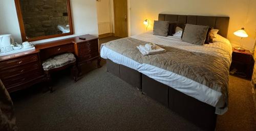 una camera d'albergo con un grande letto e uno specchio di Saughy rigg farm a Haltwhistle