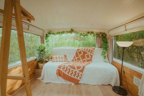 een slaapkamer met een bed en een raam bij The Amazing Inácio Bus converted home in Sintra