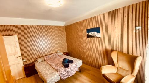 a small bedroom with a bed and a chair at villa Ada apartment in Cercivento