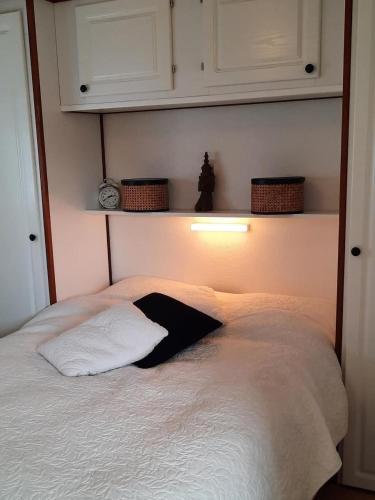 a bedroom with a white bed with a light above it at Pinkie's in Buren