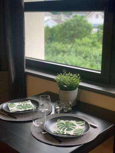 una mesa con dos platos y gafas y una ventana en Svært sentral leiligheit en Sogndal