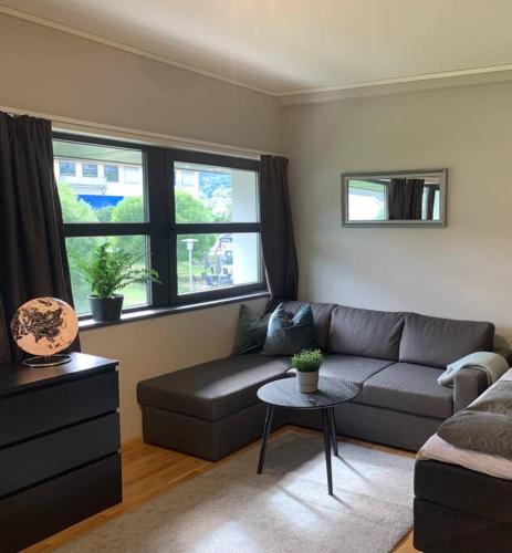 a living room with a couch and a table at Svært sentral leiligheit in Sogndal